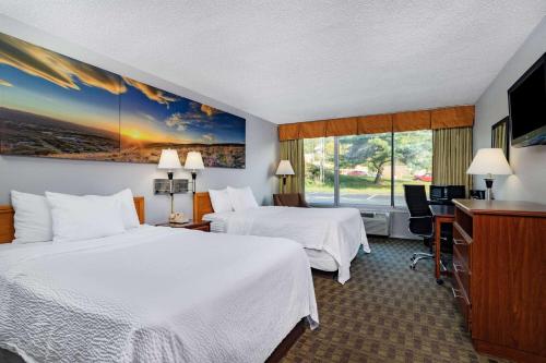 a hotel room with two beds and a flat screen tv at Days Inn by Wyndham Cambridge in Cambridge