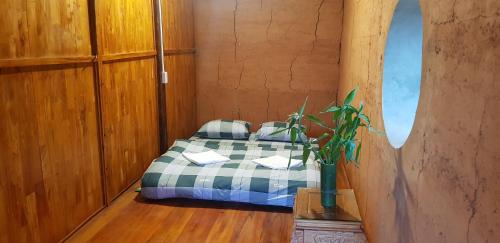 a bedroom with a bed with a plaid blanket at Diễn homestay in Quang Ba