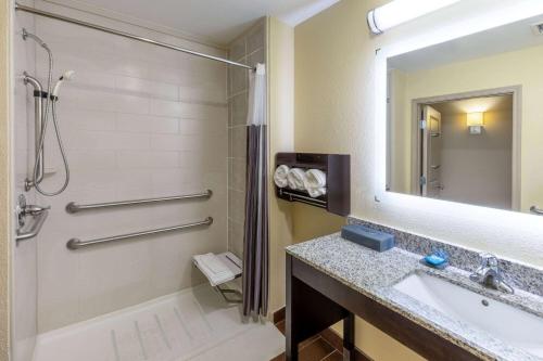 a bathroom with a tub and a sink and a mirror at La Quinta Inn & Suites by Wyndham Durant in Durant