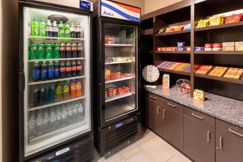 a refrigerator filled with lots of bottles of soda at La Quinta Inn & Suites by Wyndham Durant in Durant
