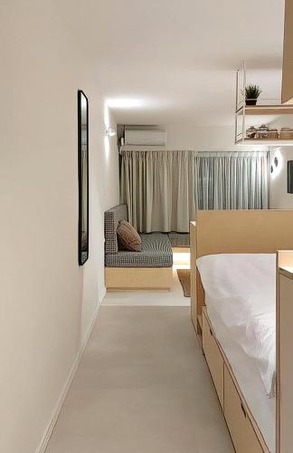 - une chambre avec un lit, une chaise et une fenêtre dans l'établissement Urban Hide, à Thessalonique