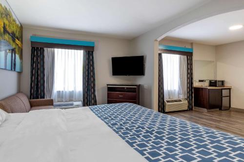 a hotel room with a bed and a flat screen tv at Clarion Pointe Sulphur - Lake Charles in Sulphur