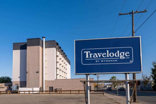 a sign in front of a large building at Travelodge by Wyndham Prince Albert in Prince Albert