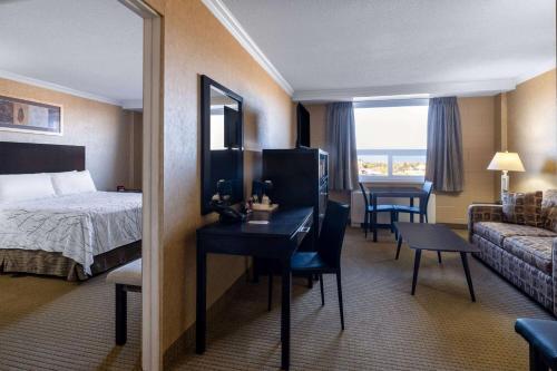 Travelodge by Wyndham Prince Albert في برينس ألبرت: غرفة فندق بسرير ومكتب وغرفة نوم