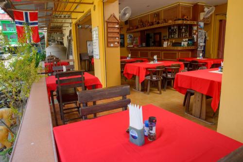 a restaurant with red tables and chairs with red table cloth at 2 Vikings Guesthouse in Karon Beach