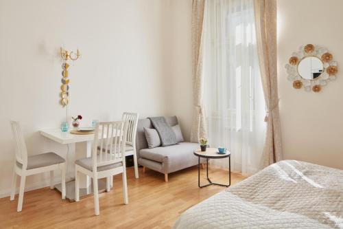 een slaapkamer met een bed, een tafel en een stoel bij Elegant Studio in New Town by Prague Days in Praag