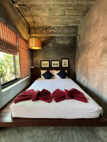 a bedroom with a large bed with red pillows at Aonang Third Place Hometel in Ao Nang Beach