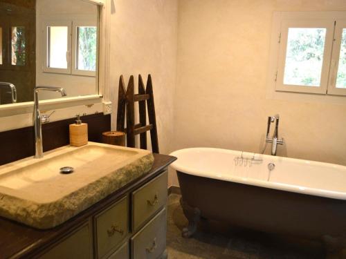 ein Badezimmer mit einer großen Badewanne und einem Waschbecken in der Unterkunft Charming holiday home in Lorgues with private pool in Lorgues