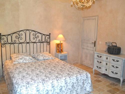 ein Schlafzimmer mit einem Bett, einer Kommode und einer Lampe in der Unterkunft Charming holiday home in Lorgues with private pool in Lorgues