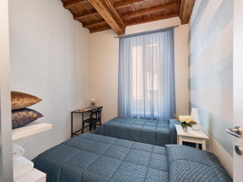 1 Schlafzimmer mit 2 blauen Betten und einem Fenster in der Unterkunft Stunning Apartment in the Heart of Florence in Florenz