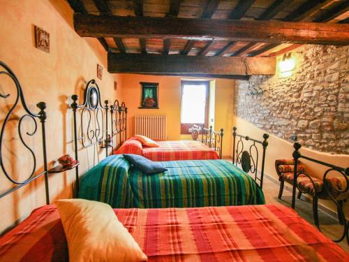a bedroom with two beds and a stone wall at Lush holiday home in Urbania with bubble bath in Urbania