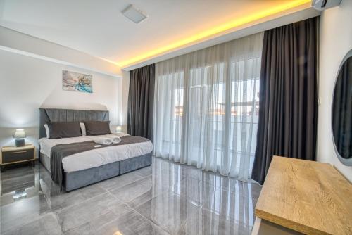 a bedroom with a bed and a large window at Courtyard Long Beach Holiday Resort in Iskele