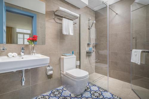 y baño con aseo, lavabo y ducha. en Central Inn Souq Waqif en Doha
