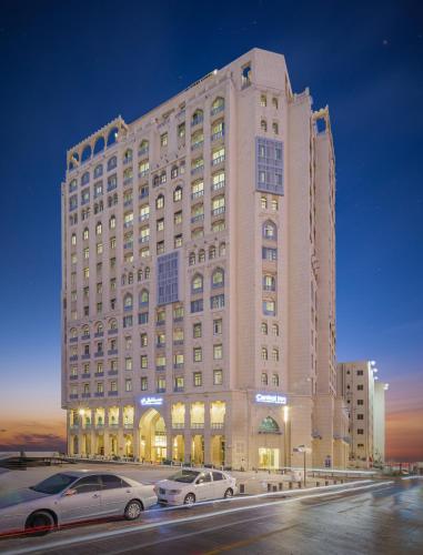 a large building with cars parked in front of it at Central Inn Souq Waqif in Doha