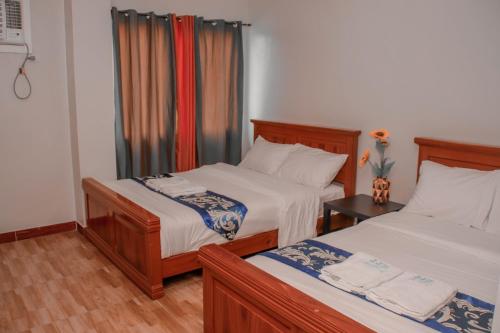 um quarto de hotel com duas camas e uma janela em JJS Hotel and Resort em San Remigio