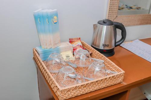 a wicker basket with glasses and a coffee maker on a desk at JJS Hotel and Resort in San Remigio