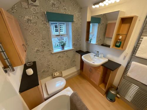 a small bathroom with a sink and a toilet at Carr’s cottage Eyam Peak District, in Eyam