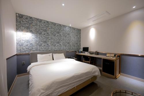 1 dormitorio con cama y escritorio. en Hound Hotel Seomyeon-Beomcheon en Busan