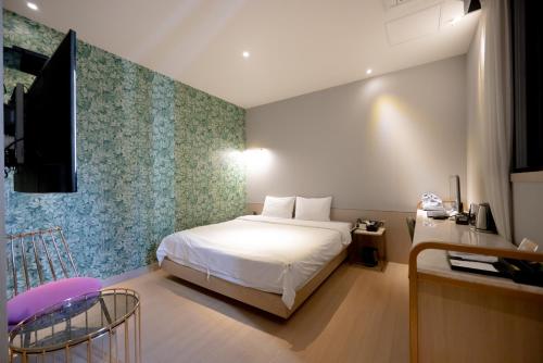 a bedroom with a bed and a tv in it at Hound Hotel Seomyeon-Beomcheon in Busan