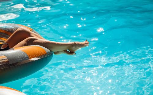a person in a swimming pool with a raft in the water at Fracanzana Hotel in Montebello Vicentino