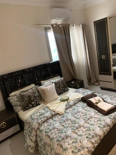 a bedroom with a bed with a dresser and a window at Résidence Moussirou 2 in Dakar