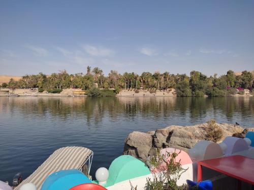 a view of a lake with two chairs and a table at Hamo Guest House in Aswan