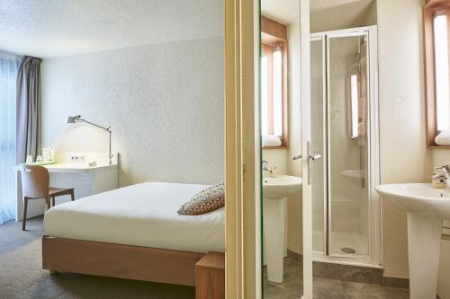 1 dormitorio con 1 cama y baño con lavamanos en Campanile Lyon Centre - Berges du Rhône, en Lyon