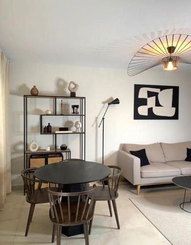 a living room with a table and a couch at Appartement Oslo - Strasbourg in Strasbourg
