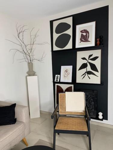 a living room with a chair and pictures on the wall at Appartement Oslo - Strasbourg in Strasbourg