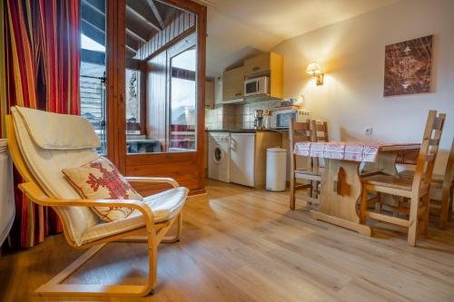 a living room with a table and chairs and a kitchen at Grand studio tout confort pour 4 personnes in Brides-les-Bains