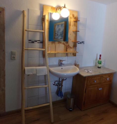 a bathroom with a sink and a ladder next to a mirror at Urlaubspension Die Mühle in Schöllnach