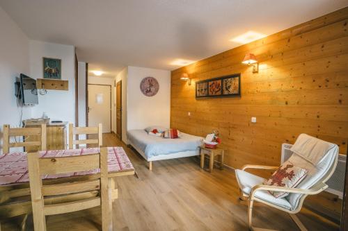 a room with a bed and a table and chairs at Grand studio tout confort pour 4 personnes in Brides-les-Bains