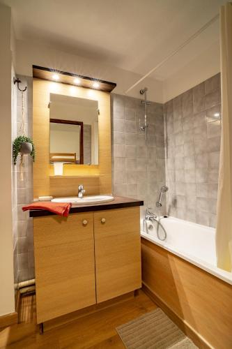 une salle de bain avec un lavabo, une baignoire et un miroir dans l'établissement Grand studio tout confort pour 4 personnes, à Brides-les-Bains