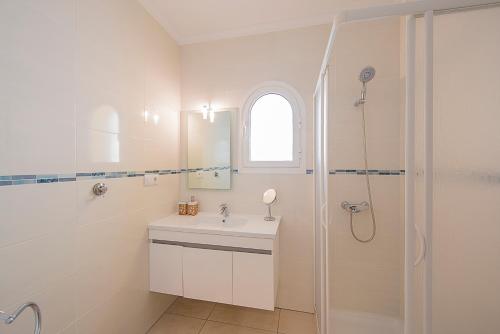 a white bathroom with a sink and a shower at Villa Castillo - PlusHolidays in Benissa