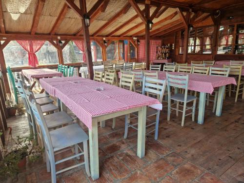 a dining room with pink tables and chairs at Kumova vodenica in Markova Crkva