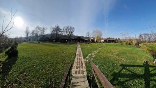 a brick path in a field with houses in the background at Kumova vodenica in Markova Crkva