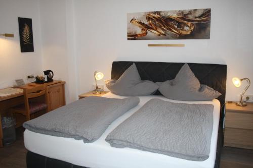 a bedroom with a bed with two pillows at Pension / Ferienwohnung Allebrodt in Lennestadt