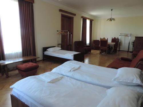 a bedroom with two beds and a table and chairs at Guest House "Old House" in Tʼelavi