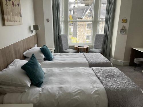 a hotel room with two beds and a window at Wordsworths Guest House in Ambleside