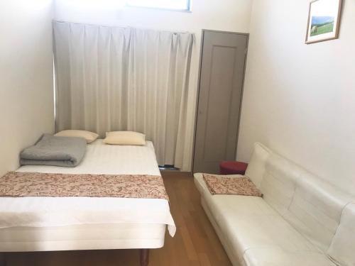 a room with two beds and a couch in it at 博多駅東貸切Hakataekihigashi Apartment LOFT付き高速WIFI 敷地内駐車場 地下鉄5分 国際線博多駅徒歩圏内 in Fukuoka