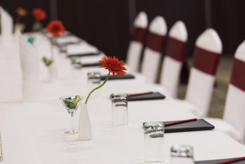 a row of tables with a red flower in a vase at The Fern Residency Galaxy Mall in Āsansol