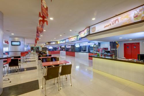 a restaurant with tables and chairs in a mall at The Fern Residency Galaxy Mall in Āsansol