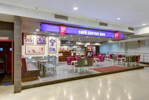 a restaurant with purple chairs and tables and a bar at The Fern Residency Galaxy Mall in Āsansol