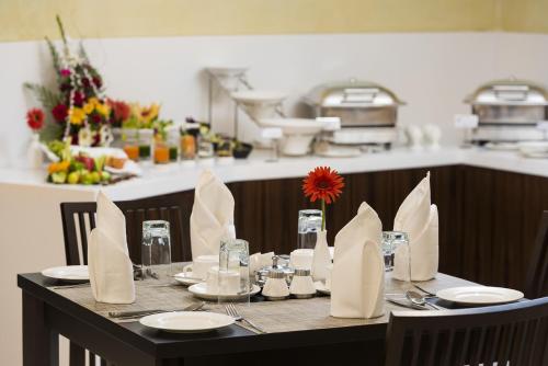 a table with plates and napkins on it in a kitchen at The Fern Residency Galaxy Mall in Āsansol