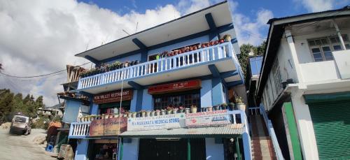 a blue and white building with a balcony at Hotel Mon Valley in Tawang