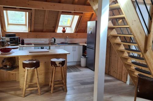 a kitchen with a counter and stools in a cabin at Les Suites du Monetier, alliant le charme et l'authenticité d'un chalet de prestige au cœur du village in Le Monêtier-les-Bains