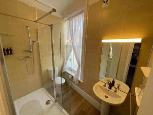 a bathroom with a shower and a sink and a toilet at The Captain's Lodge accommodation in Whitby