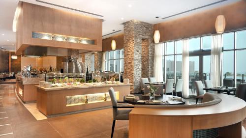 a restaurant with a table and chairs and a counter at Grand Millennium Gizan in Jazan