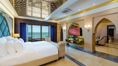 a hotel room with a bed and a television at Grand Millennium Gizan in Jazan