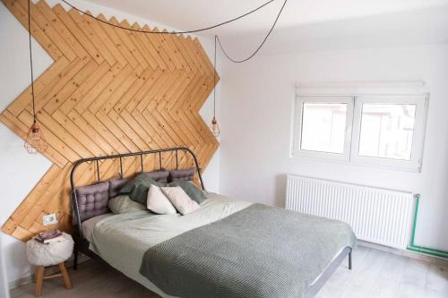 une chambre avec un lit avec une grande tête de lit en bois dans l'établissement Family home, near therme/airport/ lake, Balotesti, à Căciulaţi